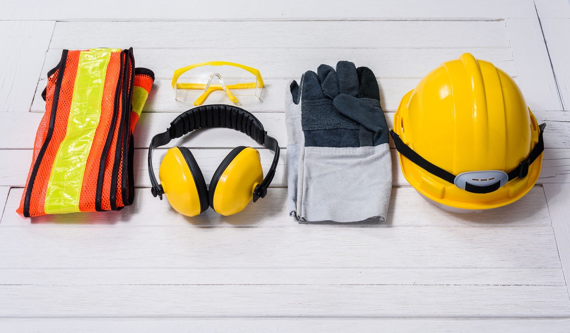 Standard construction safety equipment on white wooden background. safety first concepts